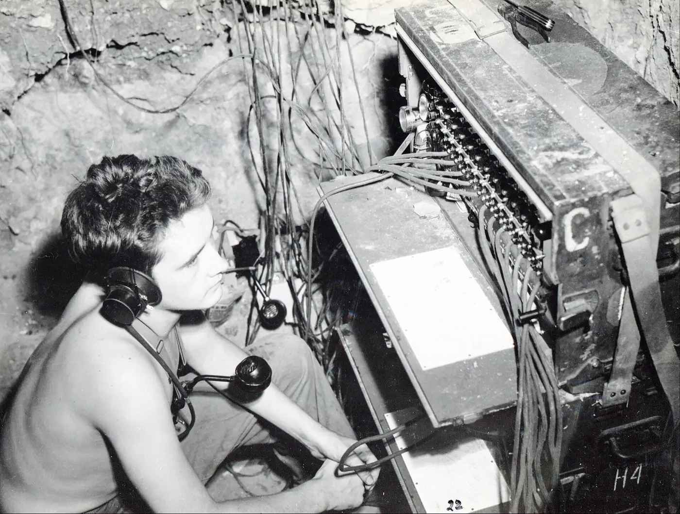 A Marine Corps switchboard operator in headphones at a field telephone exchange, circa 1942